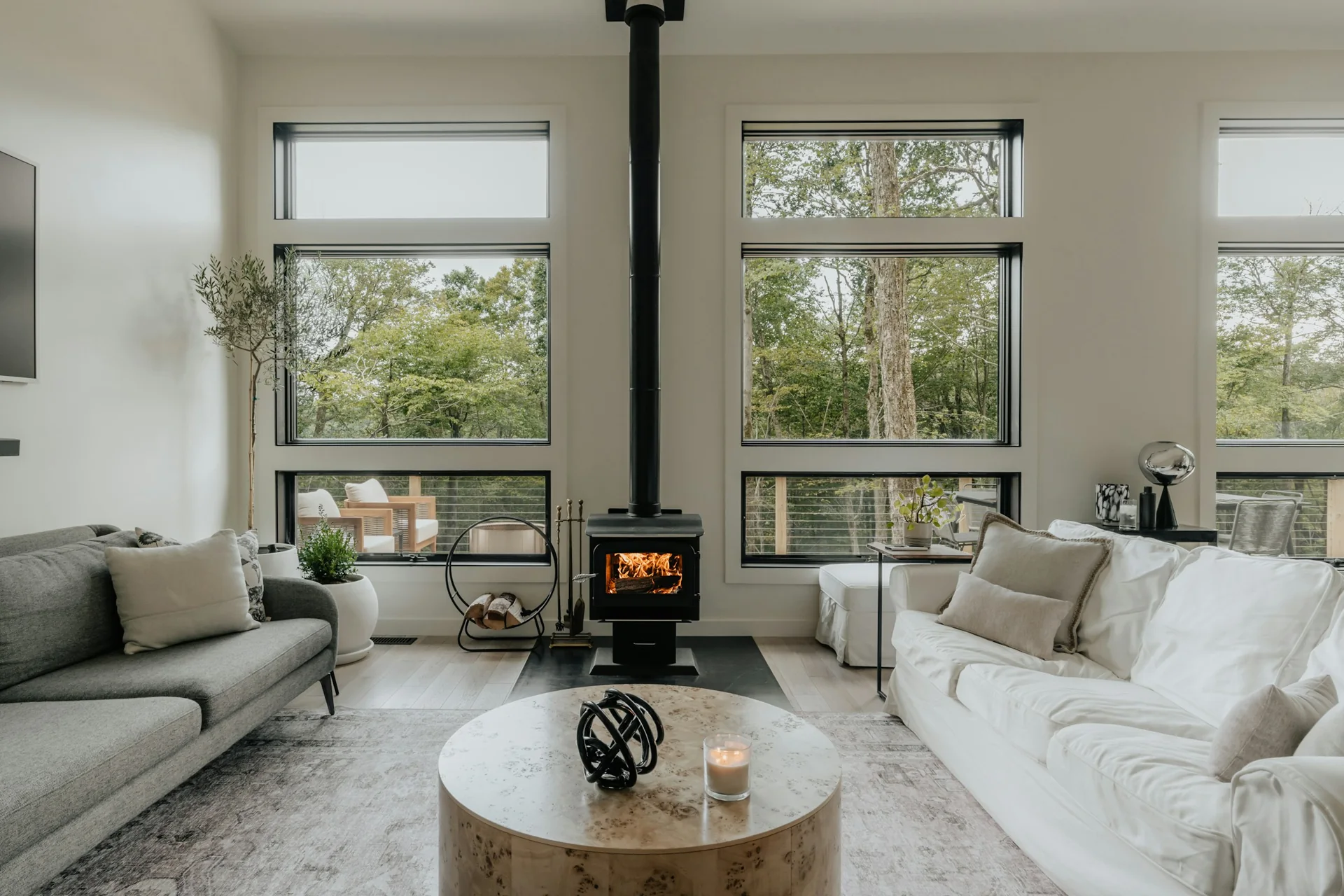 Bright living room with large windows and a wood-burning stove